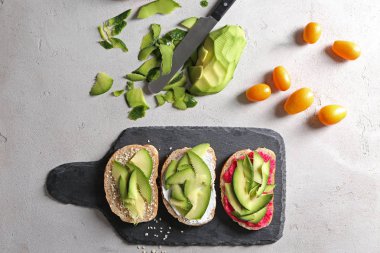 Kayrak plaka üzerinde avokado ile lezzetli tost