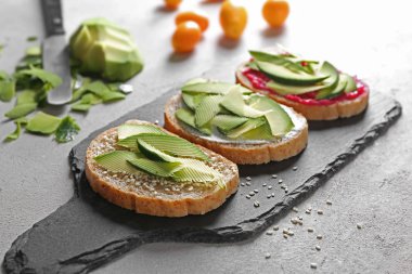 Kayrak plaka üzerinde avokado ile lezzetli tost