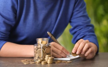 Tasarruf para ve kadın masada dolu kavanoz