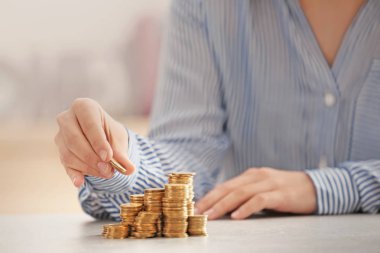 Kadın masaya bozuk para yığıyor.
