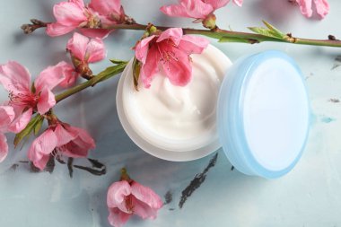 Kavanoz krem ve masaya çiçek açan çiçek