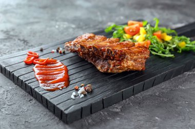 Ahşap tahta lezzetli ızgara kaburga, sos ve sebze salatası ile