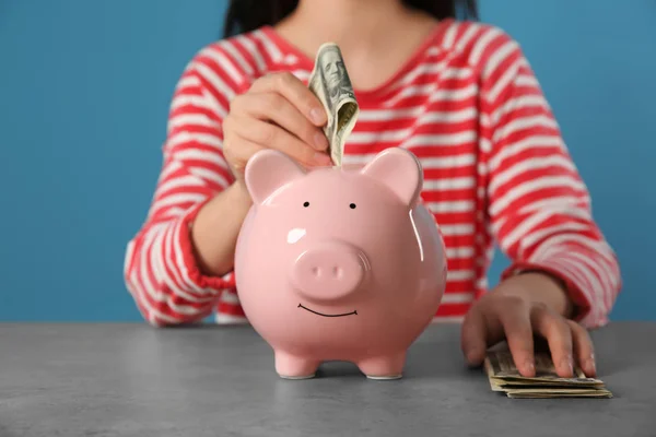 Mujer Poniendo Dinero Alcancía Mesa — Foto de Stock