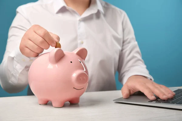 Man Putting Coin Piggy Bank Table — Stock Photo, Image