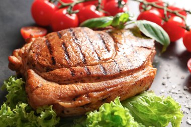 Gri arka plan üzerinde sebze ile lezzetli ızgara biftek