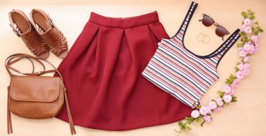 Trendy Bayan giyim ayarla, aksesuarları ve çiçek açması şube, düz ahşap arka plan üzerinde yatıyordu