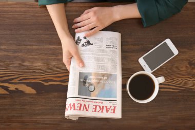 Masada gazete okuyan genç bir kadın.