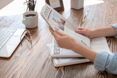 Genç kadın masada kapalı gazete okuma