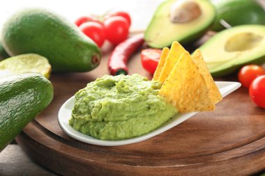 Cips ve ahşap tahta üzerinde sebze ile lezzetli guacamole
