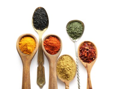 Beyaz arka plan üzerinde çeşitli baharatlar ile kaşık