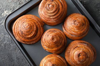 Fırın tepsisi masada tatlı tarçınlı çörek ile