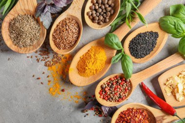 Gri zemin üzerine kaşık içinde baharatlar çeşitli