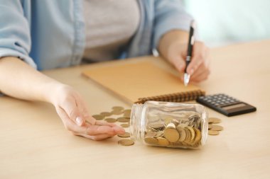 Kadın masada para sayma. Tasarruf kavramı