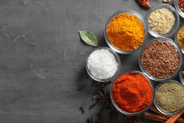 Gri arka plan üzerinde çeşitli baharatlar ile kase