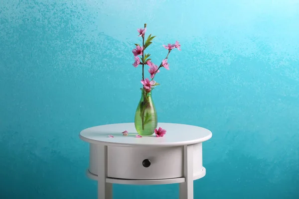 開花枝色背景にテーブルの上の花瓶 — ストック写真