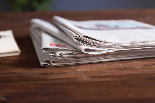 Pile of newspapers on wooden table