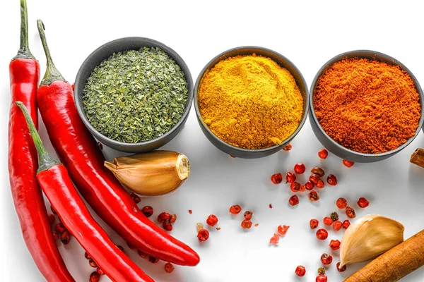 Bowls with various spices on white background