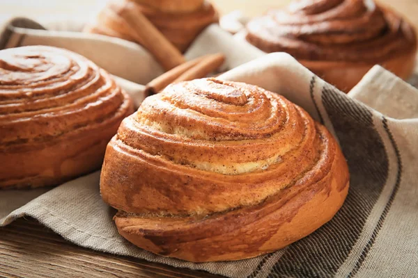 Sweet cinnamon buns on table, closeup