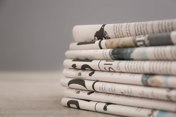 Pile of various newspapers on table