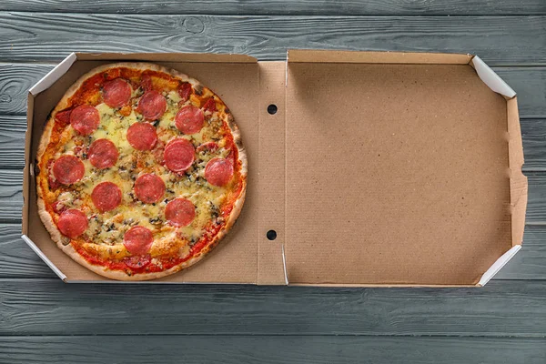 Scatola Cartone Con Gustosa Pizza Sul Tavolo Legno — Foto Stock