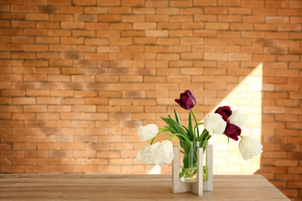 Ваза Красивыми Тюльпанами Деревянном Столе Против Кирпичной Стены — стоковое фото