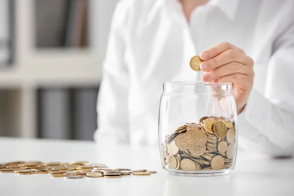 Woman Putting Coins Glass Jar Table Savings Concept — Stock Photo, Image