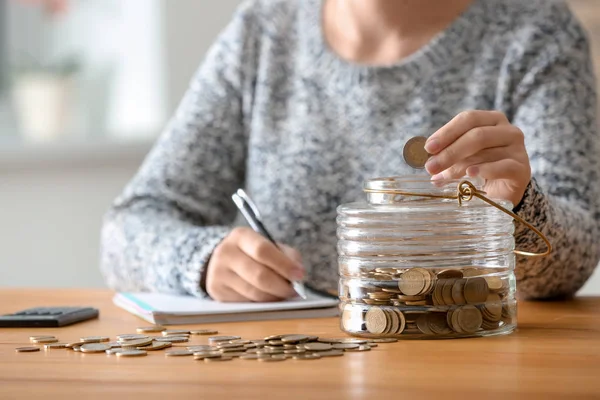 Woman Putting Coins Glass Jar Table Savings Concept — Stock Photo, Image