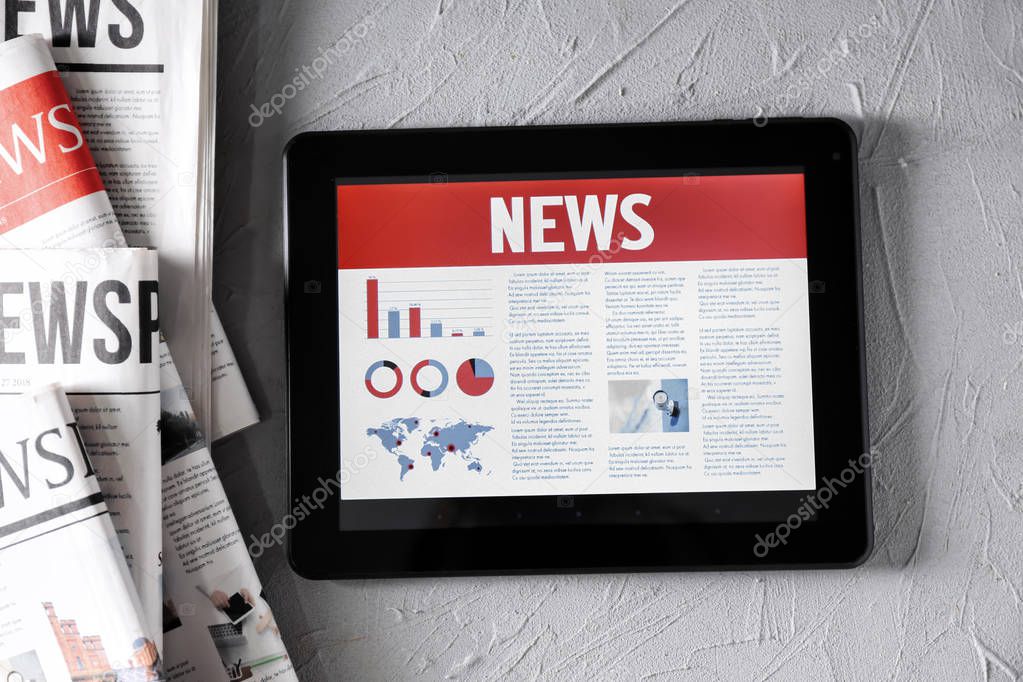 Tablet computer with news on screen on textured background