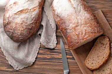 Bıçak ve tahta ahşap masa kesilmiş taze lezzetli ekmek ile