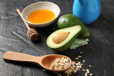 Avokado için koyu renk arka plan üzerinde doğal ev yapımı kozmetik malzemeler ile