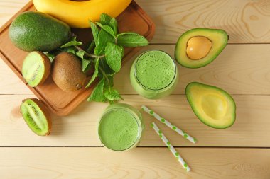 Lezzetli avokado güler yüzlü ve malzemeler ahşap tahta üzerinde gözlük