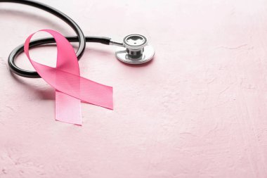 Renkli arka planda pembe kurdele ve steteskop. Göğüs kanseri farkındalığı konsepti