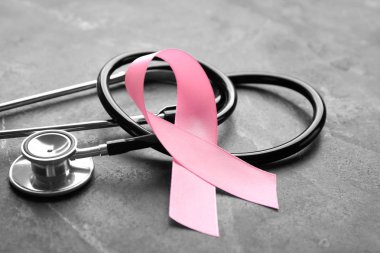 Pembe kurdele ve gri arka plan, closeup stetoskop. Meme kanseri bilinçlendirme kavramı