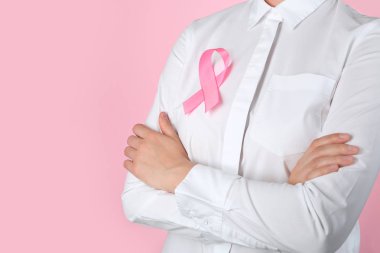 Doktor elbise renkli arka plan üzerinde pembe kurdele ile. Meme Kanseri Bilinçlendirme kavramı