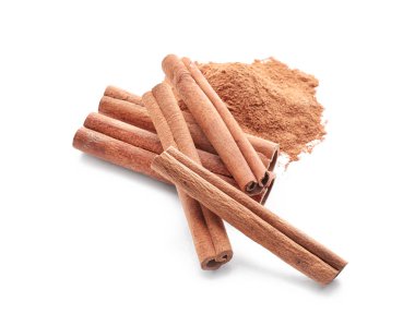 Aromatik tarçın çubukları ve beyaz arkaplanda pudra