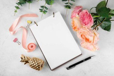 Güzel çiçekler ve açık renkli defter kompozisyonu