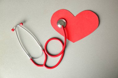 Kırmızı kağıt kalp ve stetoskop ışık arka plan üzerinde. Sağlık kavramı