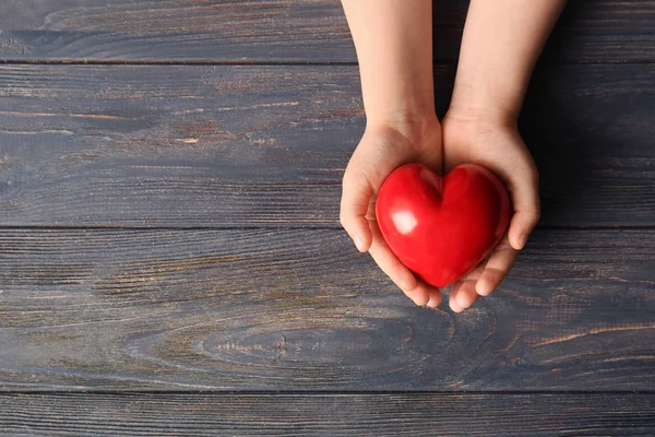 Manos Niño Con Corazón Rojo Sobre Fondo Madera — Foto de Stock