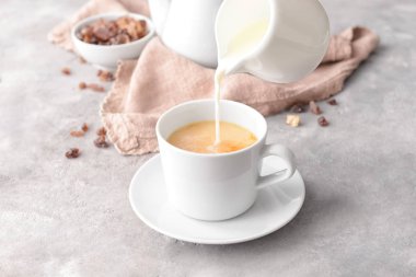 Süt çay fincan masanın üstüne dökme.