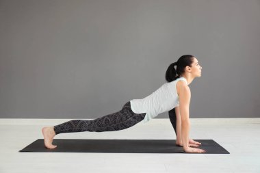 Evde yoga yapan genç bir kadın.