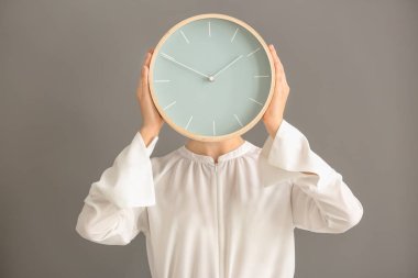 Gri arka plan üzerinde saat olan kadın. Zaman yönetimi kavramı