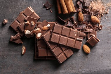 Sütlü çikolata parçaları ile badem gri arka plan üzerinde