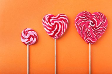 Lezzetli tatlı lolipop düz renkli arka plan üzerinde yatıyordu