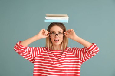 Renkli arka plan kitapları olan genç bir kadın.