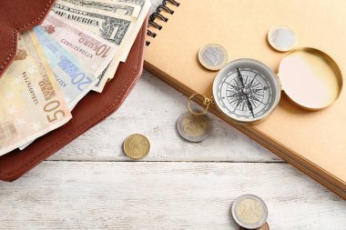 Para, pusula ve dünya harita üzerinde ahşap arka plan ile kompozisyon. Seyahat kavramı