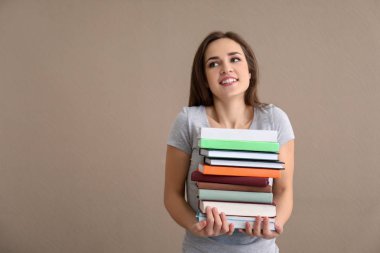 Renk arka plan üzerinde kitap yığını olan kadın