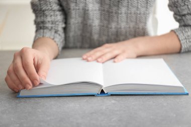 Genç kadın okuma kitabı masada, portre