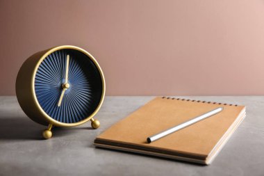 Masa üstünde defter ile çalar saat. Zaman yönetimi kavramı