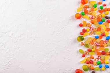 Üstten görünüm beyaz dokulu arka plan üzerinde renkli şekerler