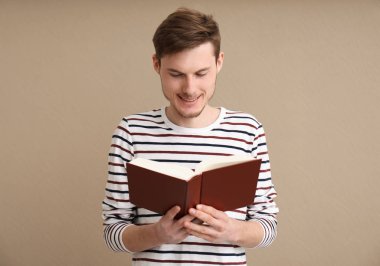Genç adam renk arkaplanı kitabı okuyor
